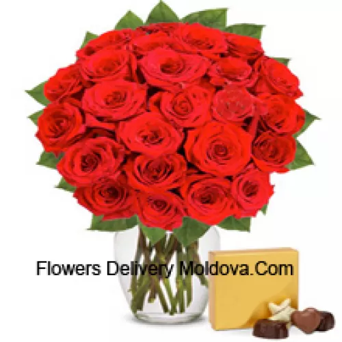 31 roses rouges avec des fougères dans un vase en verre accompagnées d'une boîte de chocolats importés