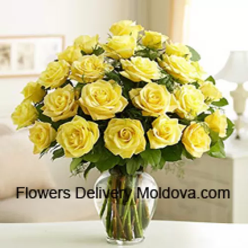 25 Roses jaunes divines avec quelques fougères dans un vase en verre