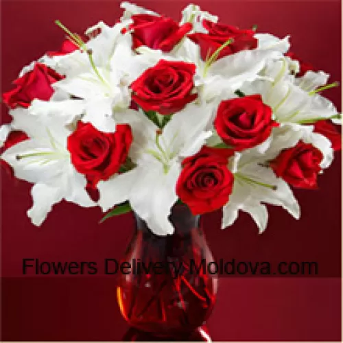 Red Roses And White Lilies With Some Ferns In A Glass Vase