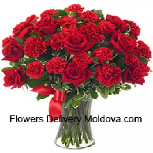 15 Red Roses And 10 Red Carnations With Some Ferns In A Glass Vase