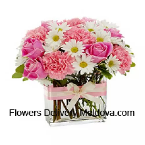 Roses roses, œillets roses et diverses fleurs blanches de saison disposées magnifiquement dans un vase en verre