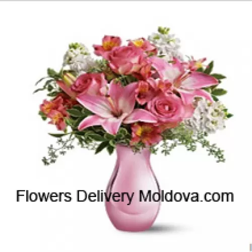 Roses roses, lys roses et fleurs blanches assorties avec quelques fougères dans un vase en verre