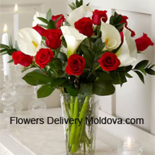 Roses rouges et lys blancs avec des fougères dans un vase en verre