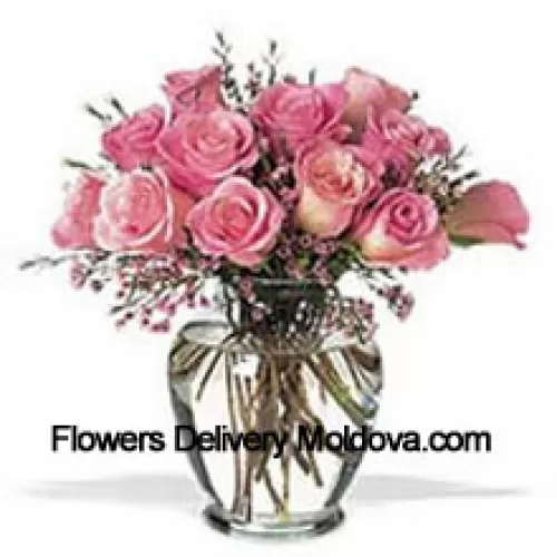 Bouquet de 11 roses roses avec quelques fougères dans un vase