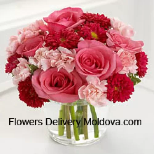7 roses roses, 10 marguerites de couleur rouge et 10 œillets de couleur rose dans un vase en verre
