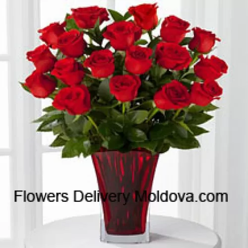 19 Roses rouges avec garnitures saisonnières dans un vase en verre décoré d'un nœud rose